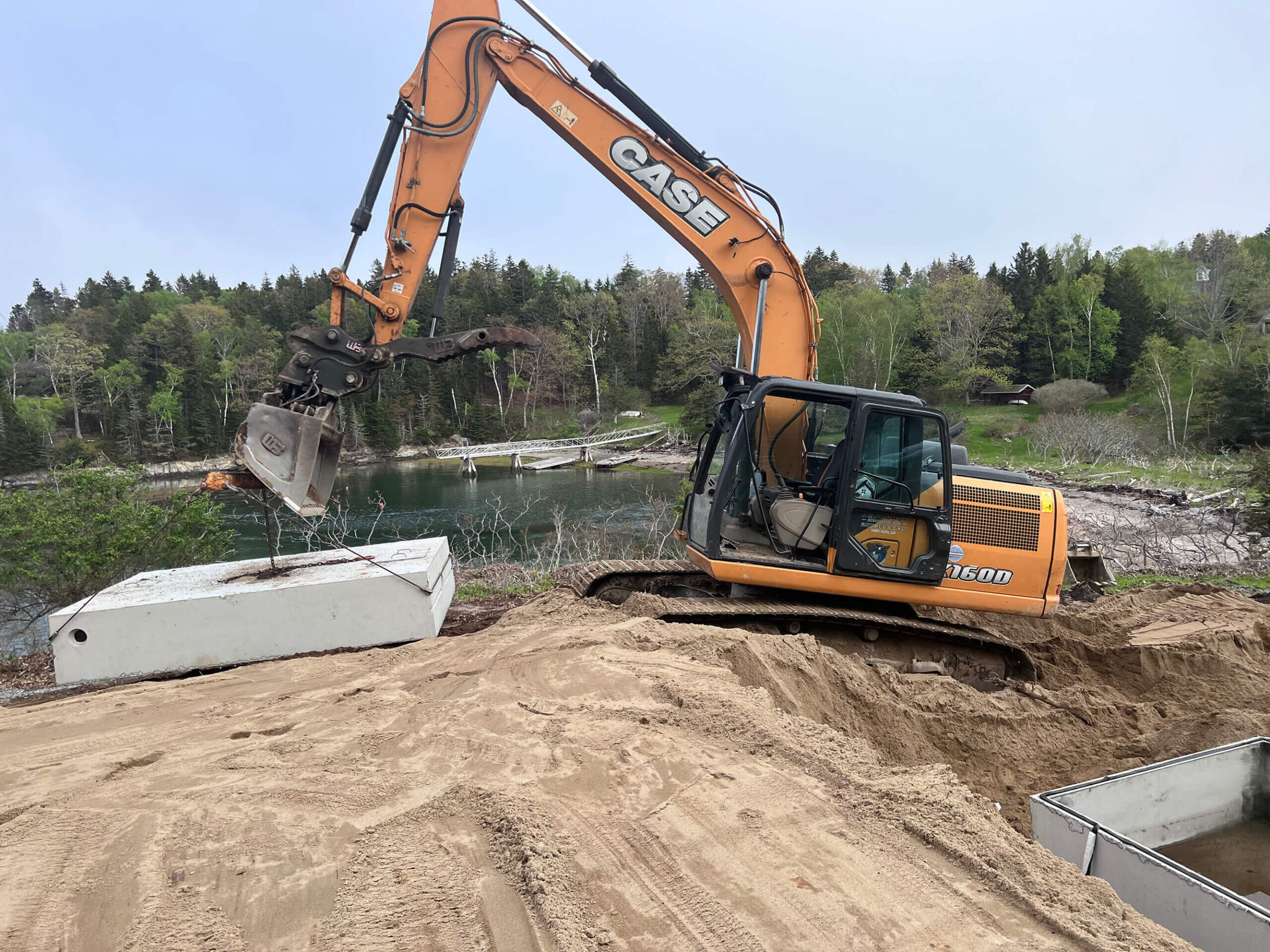 Construction Project: Excavator picking up concrete septic tank for Residential Site Development on Haskell Island
